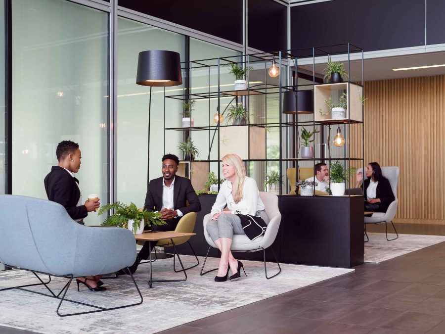 People having a discussion in an office park lounge area