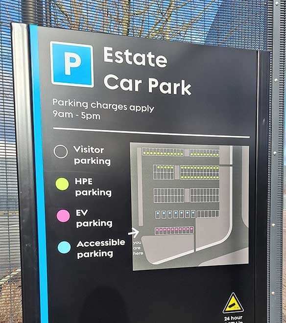 Estate Car Park sign showing parking charges, hours, and a colour-coded map for visitor, HPE, EV, and accessible parking areas.