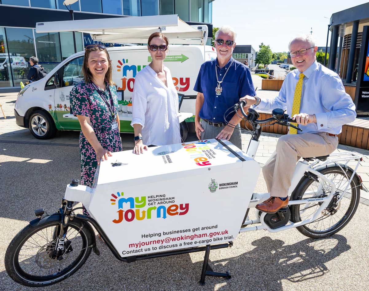 Four people pose with an electric cargo bike branded My Journey outside a van, promoting a business transport initiative in Wokingham.