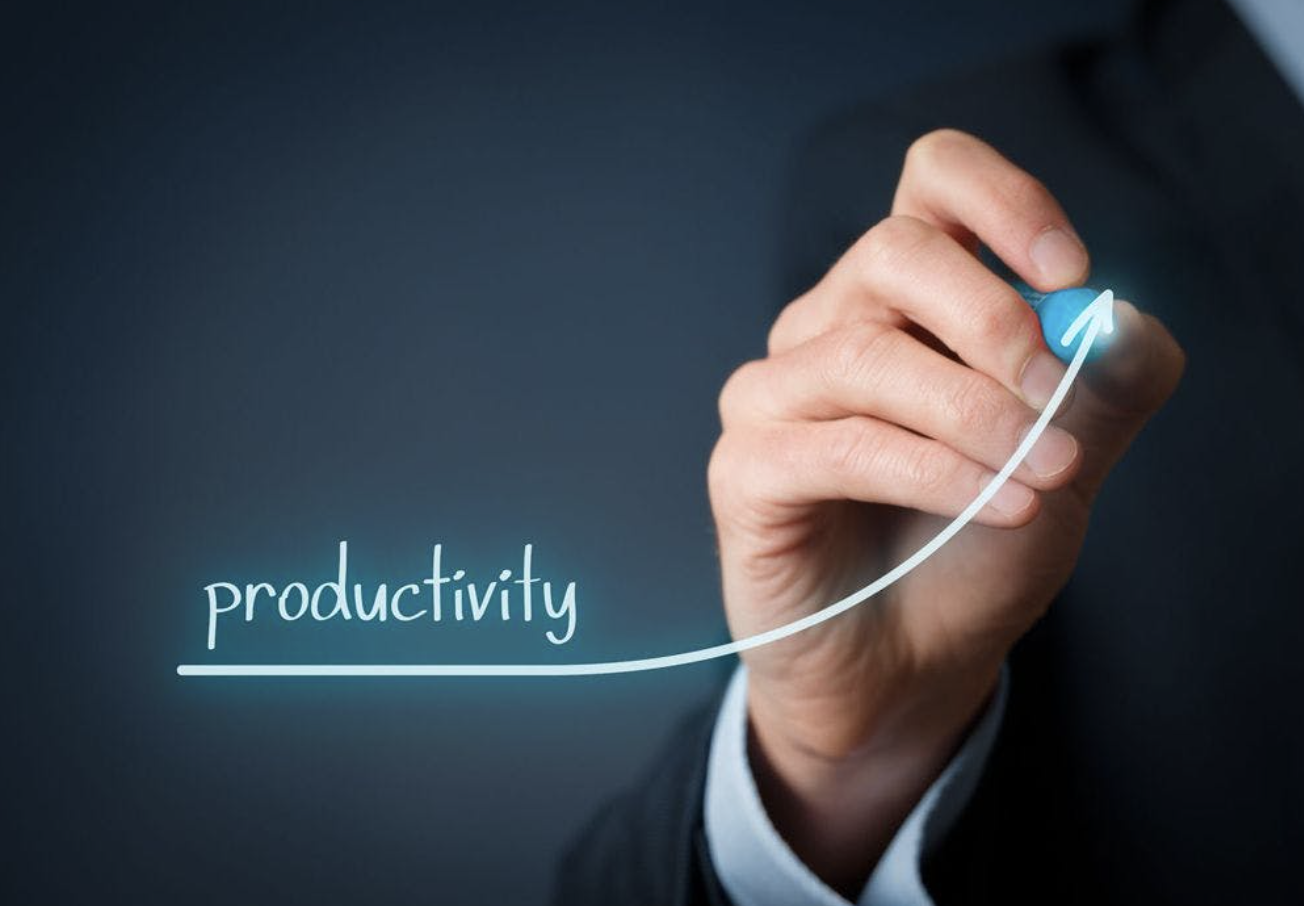 A person in business attire draws an upward arrow next to the word productivity, symbolising an increase in productivity.